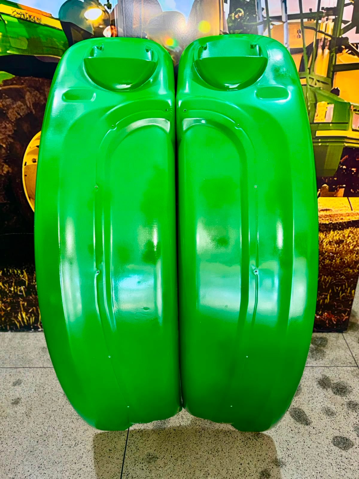 Detalhe do par de paralamas John Deere ao lado de pneu de trator